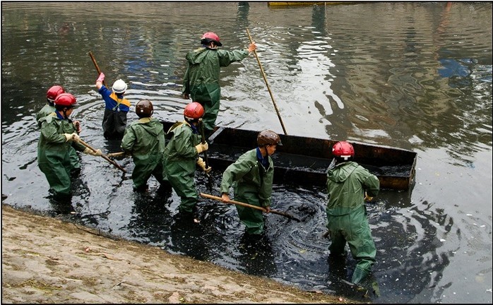 Công nhân vớt bùn trên sông
