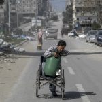Cậu bé ở Gaza dùng xe lăn để chuyển nước